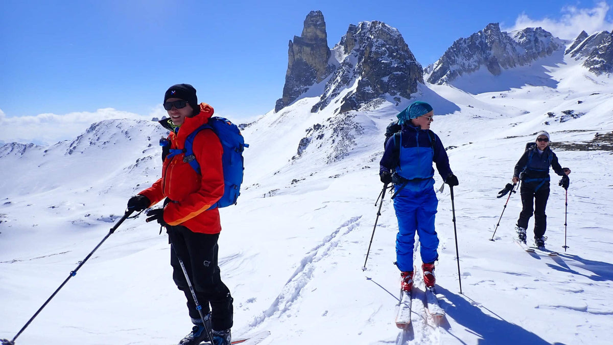 Groupe de skieurs de randonnée en montée, aiguilles rocheuses en arrière-plan