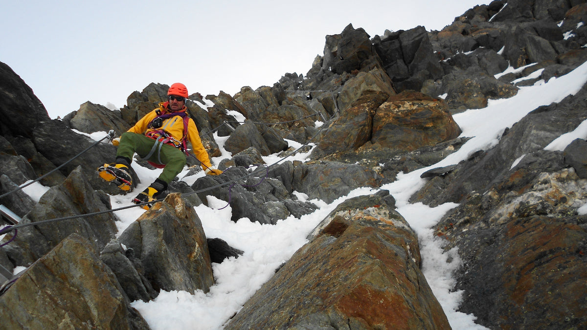 Alpiniste progressant dans un terrain mixte de rochers et de neige