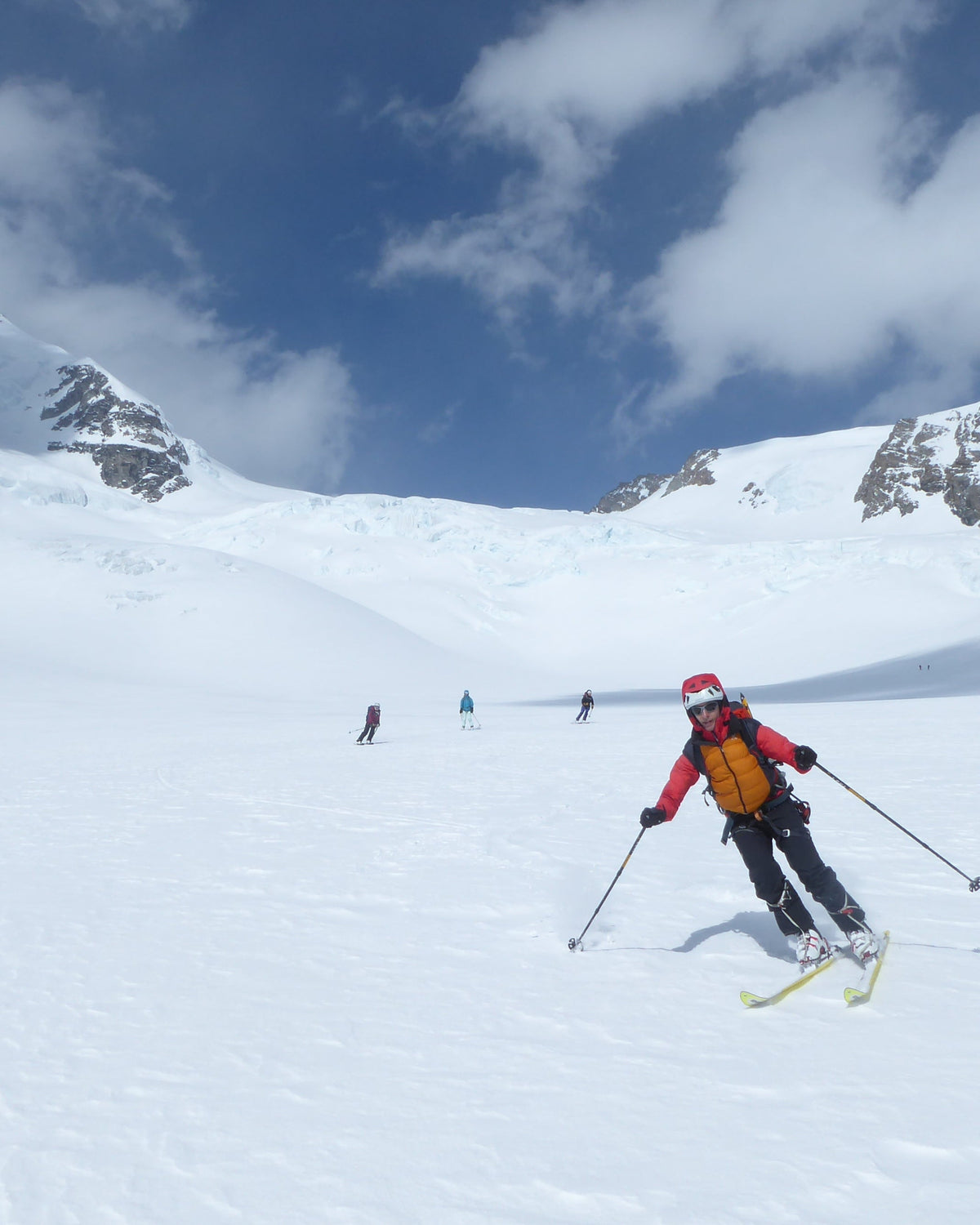 Skieur en descente sur un glacier sous un ciel bleu