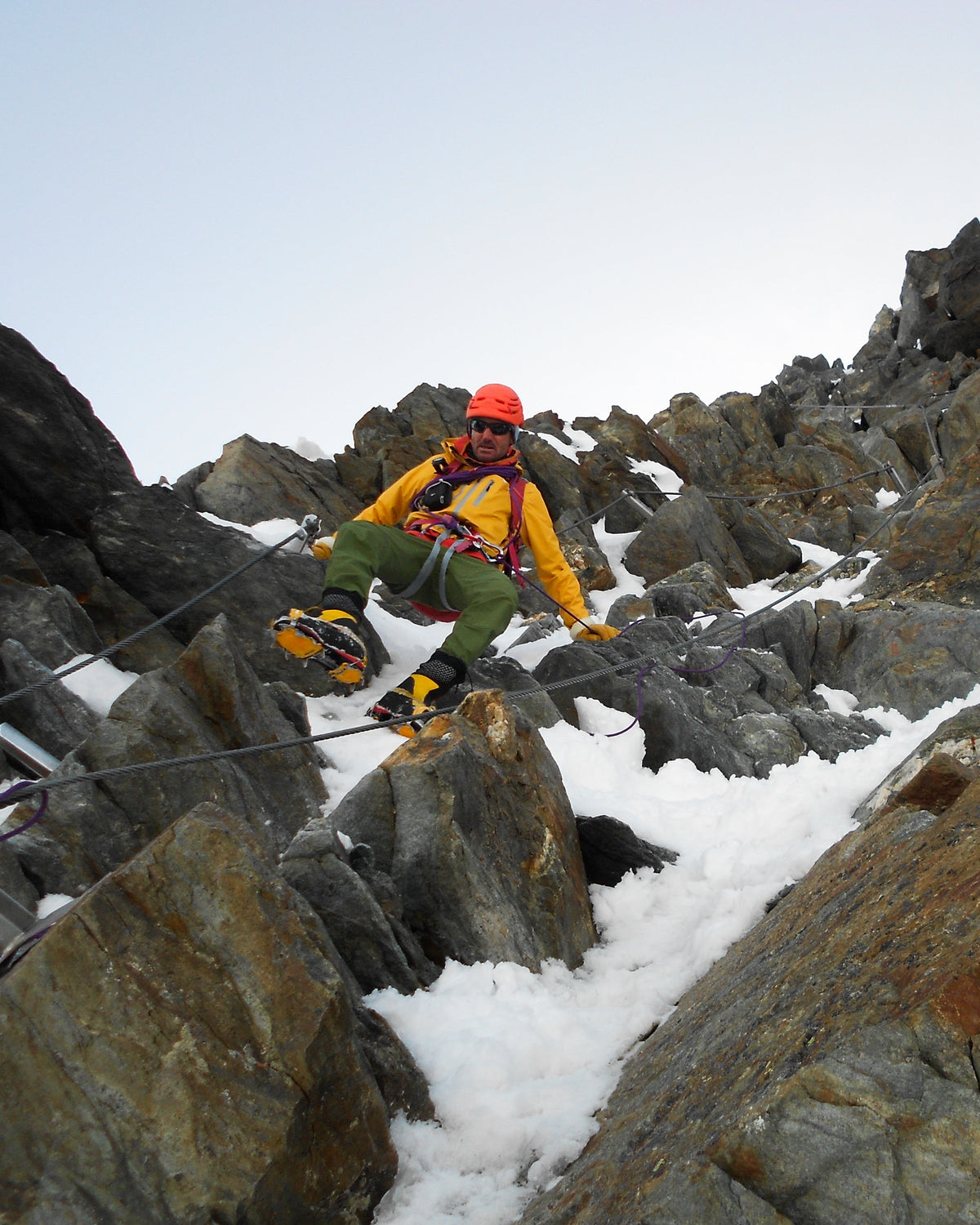 Alpiniste progressant dans un terrain mixte de rochers et de neige