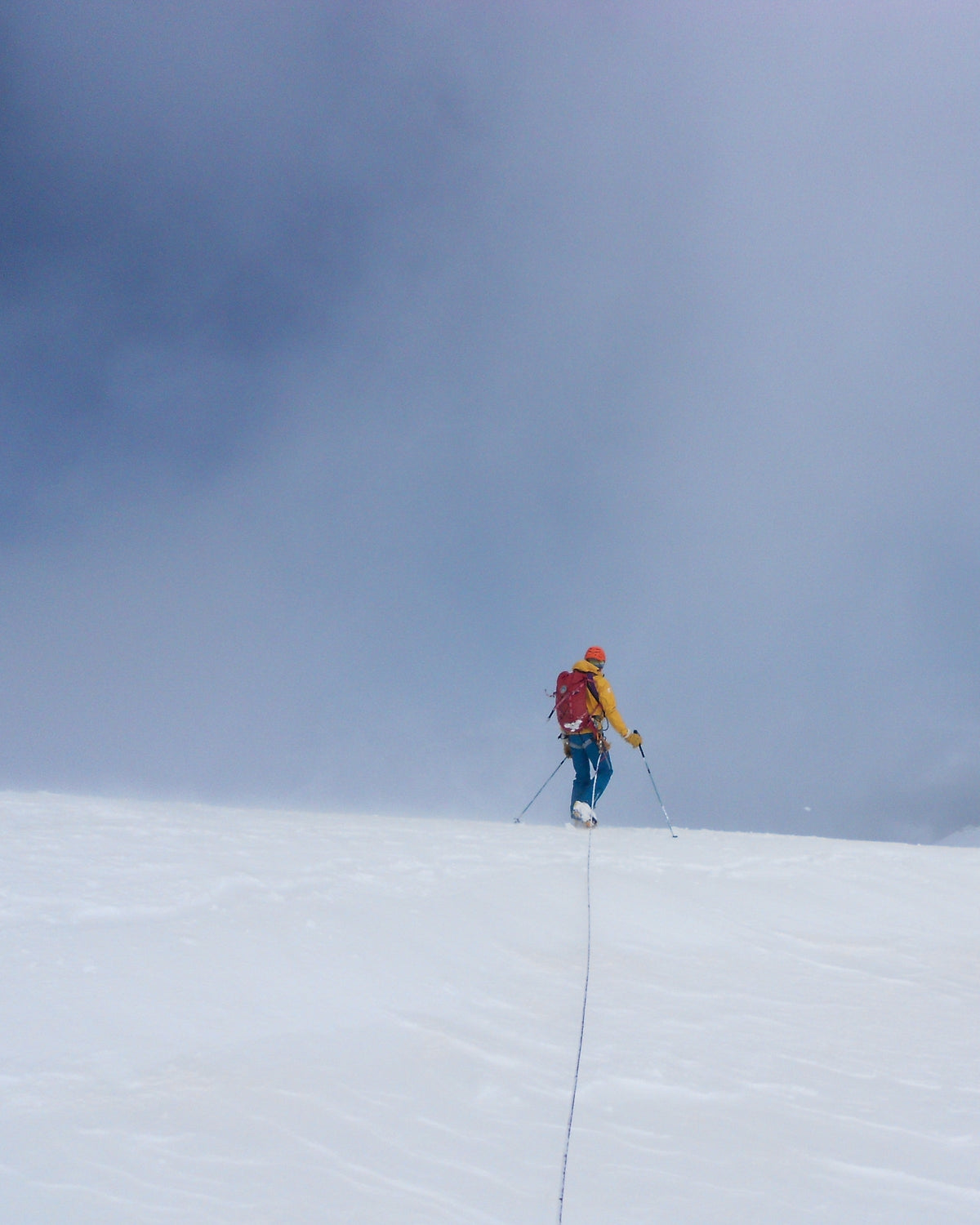 Alpiniste progressant dans la brume sur un glacier