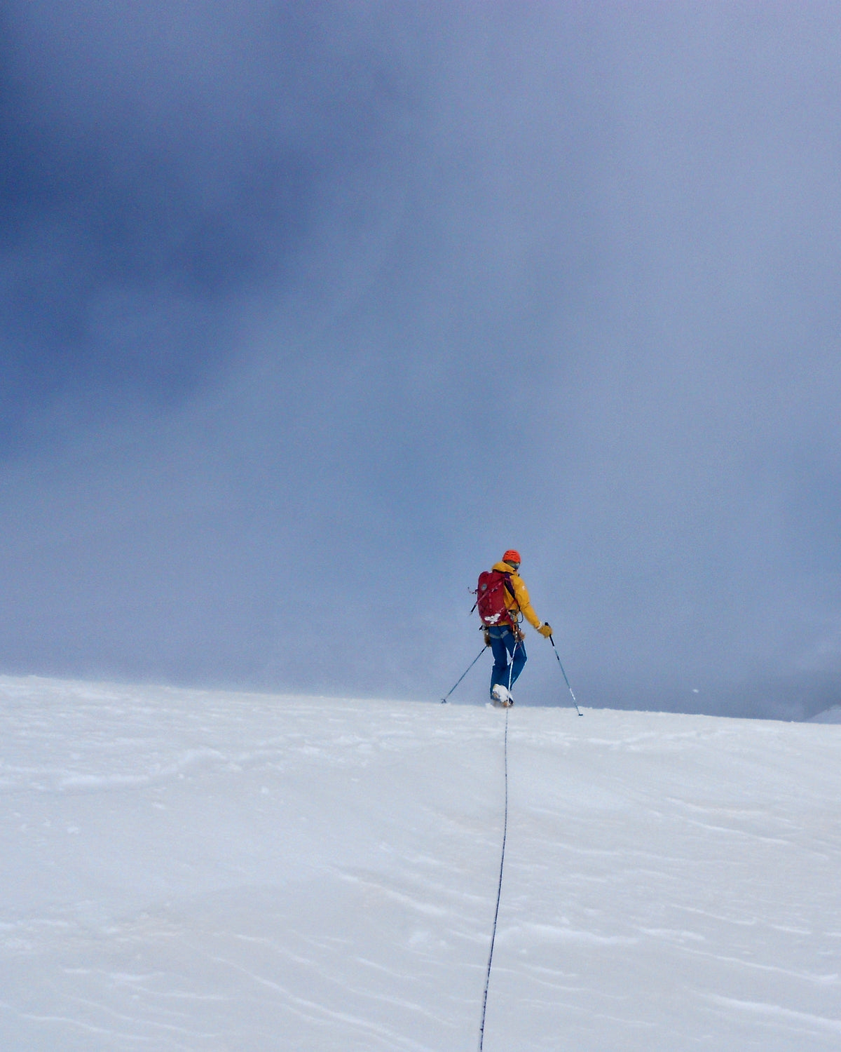 Alpiniste progressant seul sur un glacier enneigé lors d'une sortie d'alpinisme hivernal