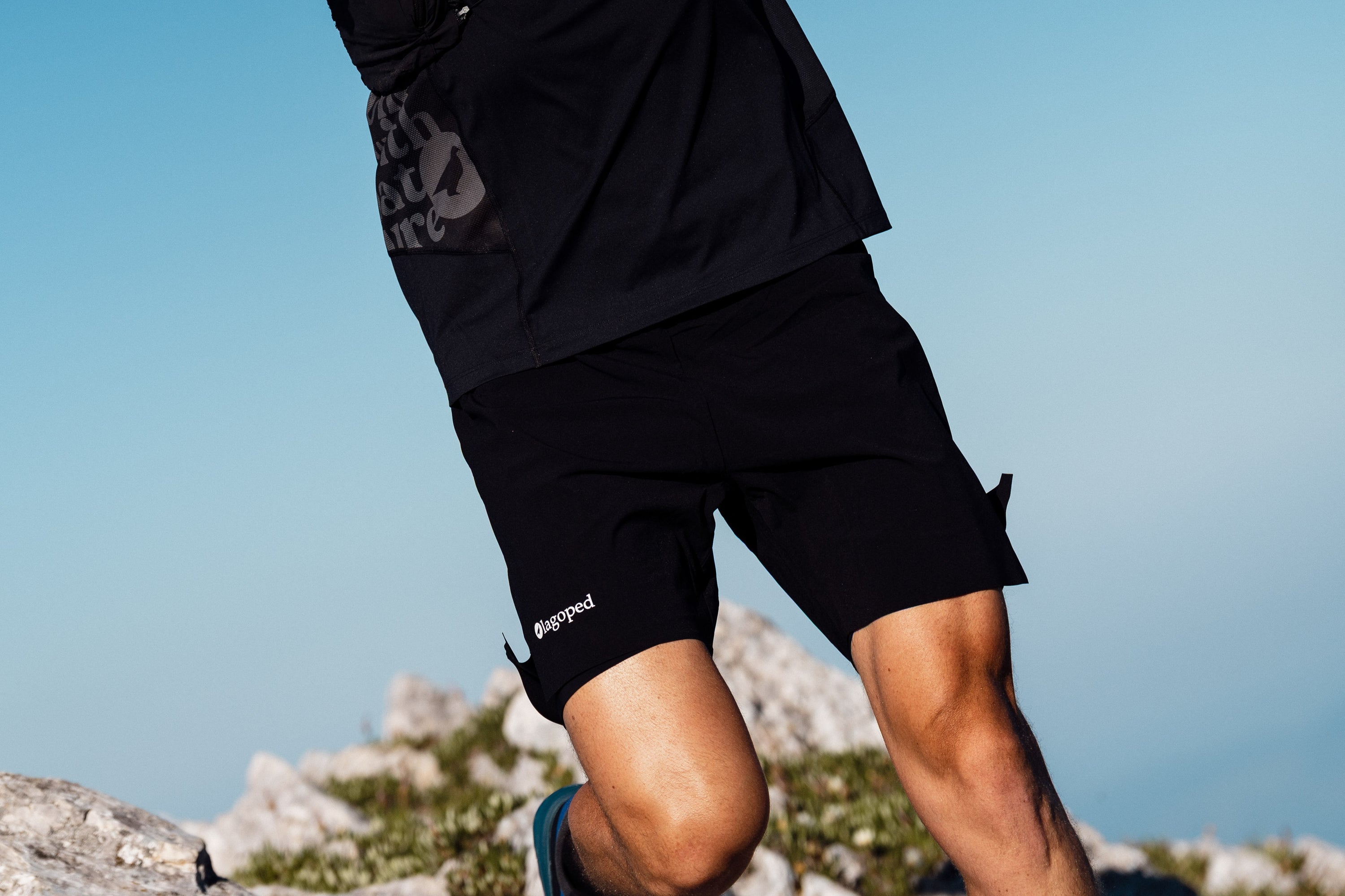 Homme portant un short Lagoped Milvus noir, trail running en été en montagne