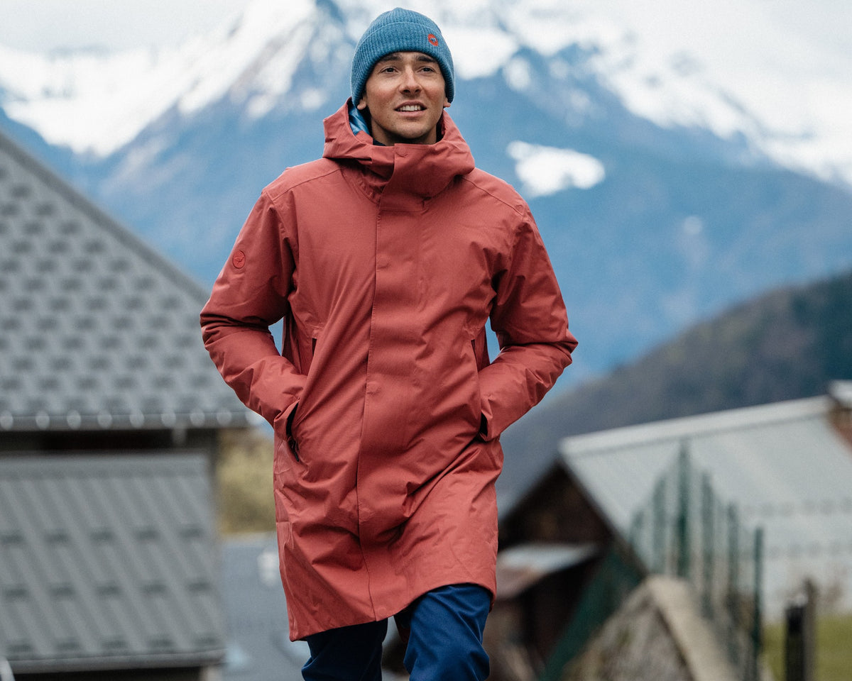 Homme marchant dans un village de montagne portant la veste 3/4 chaude Lagoped GRAND TETRAS WARM ocre, en hiver