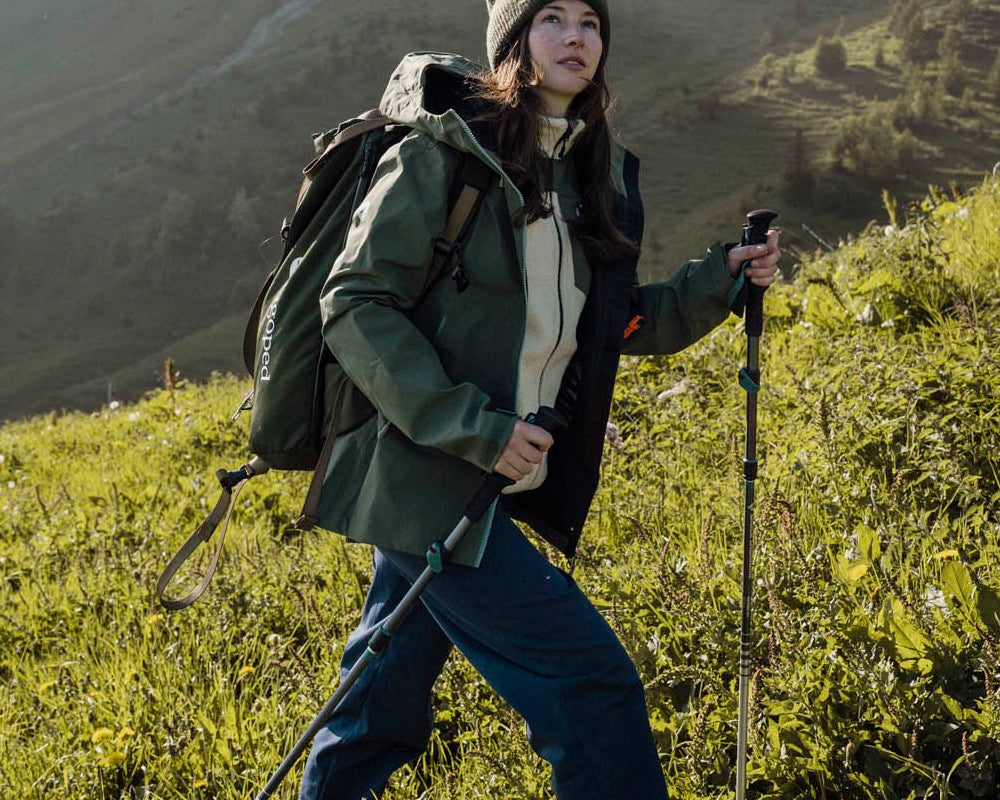 Femme en randonnée dans un alpage portant la veste rando-montagne Lagoped TETRAS thym, en été